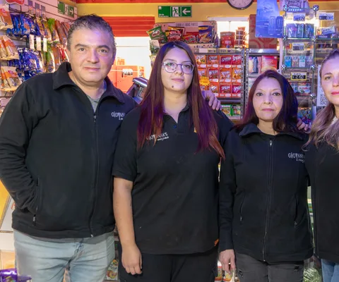 Equipo de un almacén familiar posando tras el mesón