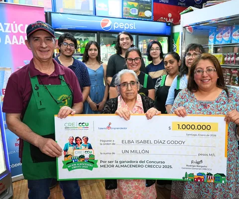 Grupo celebrando en un almacén con el cheque de premio de Elba Isabel Díaz Godoy, ganadora del Mejor Almacenero CRECCU 2025