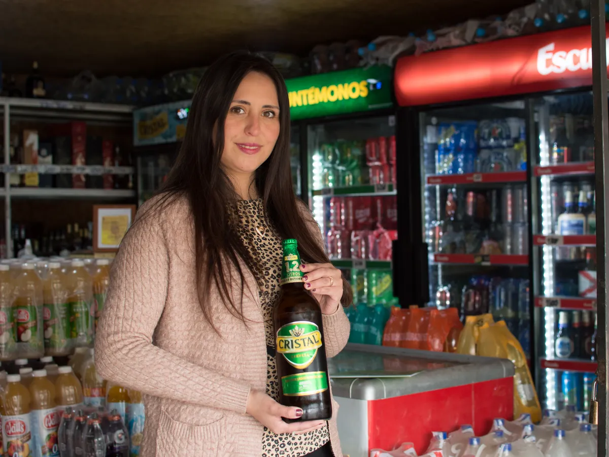 Almacenera en su local, rodeada de los productos que ofrece a sus clientes