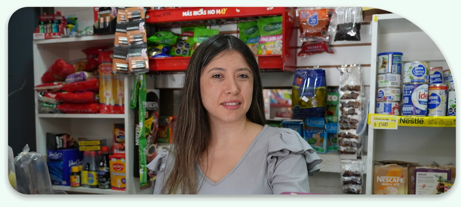 Almacenera sonriente atendiendo detrás del mesón de su negocio